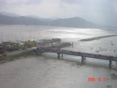 写真：円山川右岸の堤防決壊現場。立野大橋には救助のために駆けつけた緊急車両が並ぶ