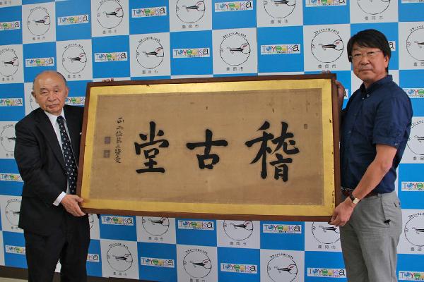 写真：中貝市長（右）へ扁額を手渡す京極高晴さん