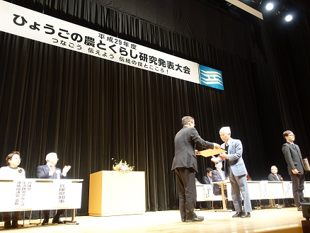 写真　岡田会長の授賞式の様子