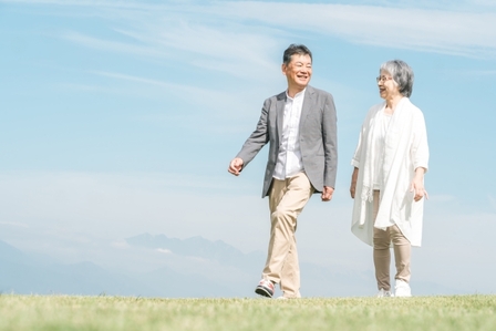 夫婦が笑顔で散歩しているイメージ画像