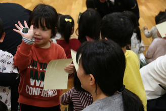 写真：もらった瑞風のシールを手に貼って先生に見せる女の子