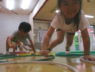 写真：床に並べられた輪の中に手足をついて進む子ども