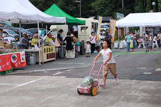 写真：スイカを2輪車に乗せて走る嶋さん