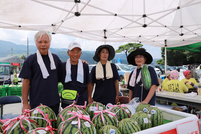 写真：スイカを販売する4人