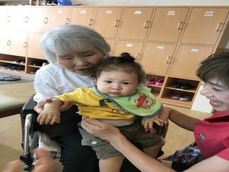 写真：おばあちゃんに抱かれる子ども