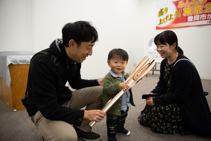 トーチにふれる家族連れ