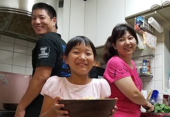 写真：坂井さん夫婦と娘で一緒に料理