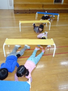 写真：園児がベンチのトンネルで遊んでいる様子