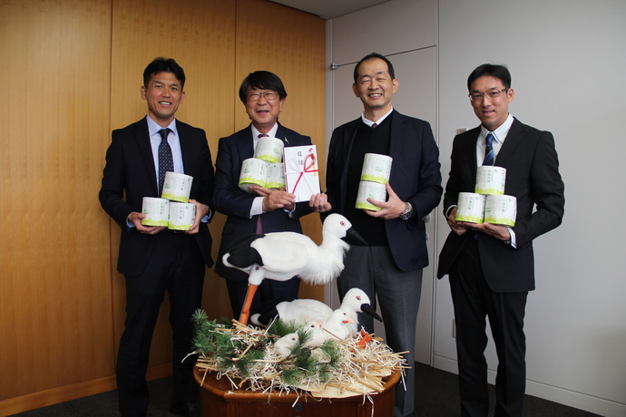 同社製品と目録を手にして撮影