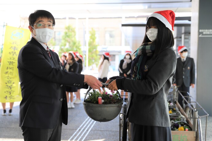 写真：田中会長から市役所総務課長補佐にプランターの贈呈