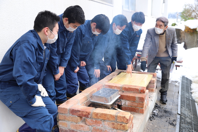 写真：防災かまどベンチについて説明する生徒たち