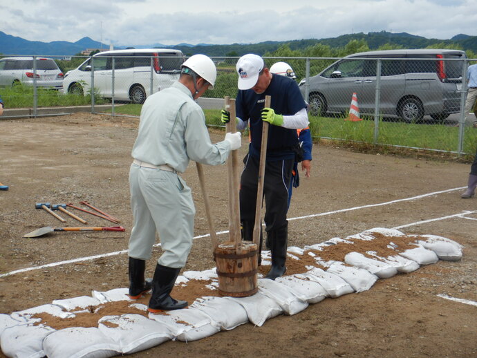 写真:積んだ土のうを踏み固める