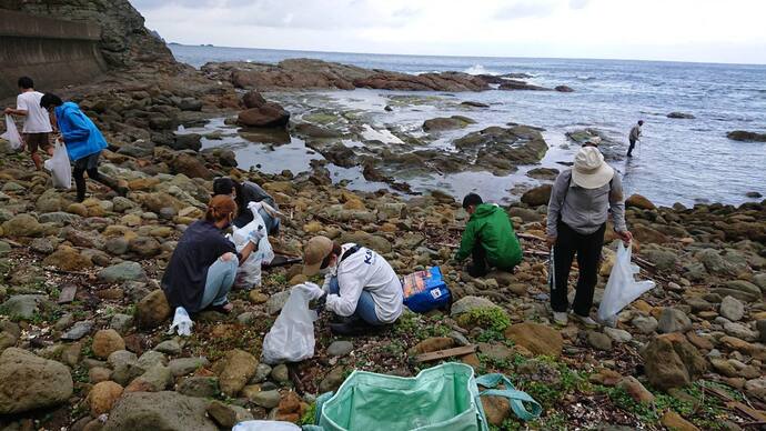 猫崎半島の海辺でごみ拾いしている様子