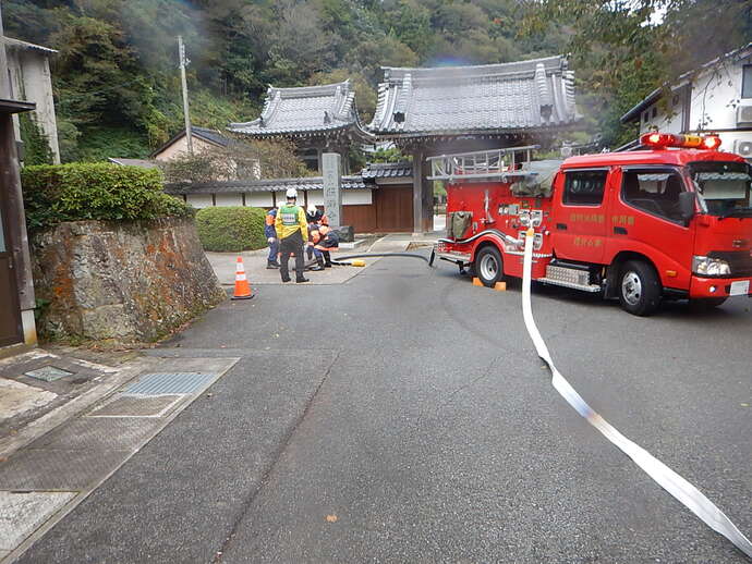 防火水槽から給水する消防団員