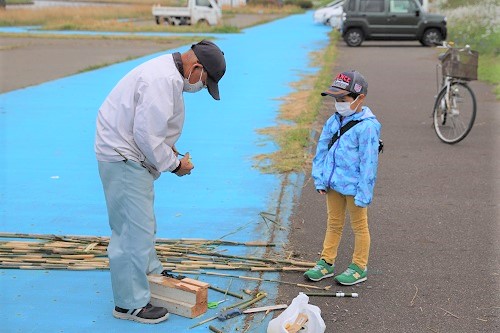 写真：地元の方と一緒に竹鉄砲を作る子ども