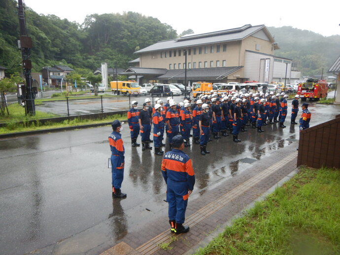 悪天候により訓練を途中で終了し整列する消防団員の写真