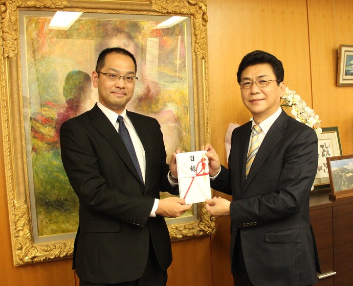 写真：一緒に目録を持つ関貫市長(右)と松岡副委員長(左)