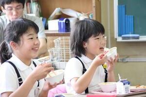 コウノトリ育むお米を食べる子ども