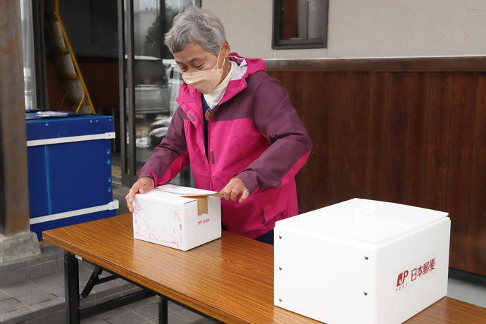 写真：箱から荷物を取り出す女性