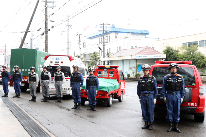 支援車両の前に整列する職員