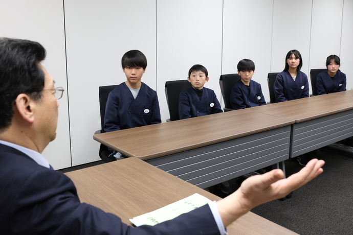 写真：市長の話を聞く児童5人