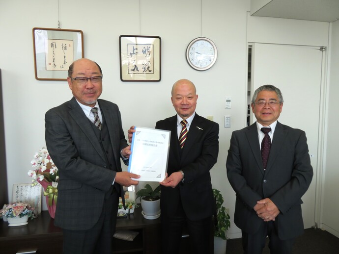 写真:嶋教育長に報告書を手渡す水嶋委員長と山内副委員長