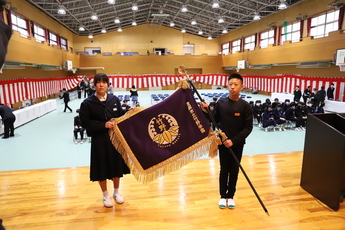 竹野学園開校式 生徒2人で学園旗を持っている