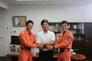 写真：門間市長と握手する消防本部の鍵井さんと浅間さん