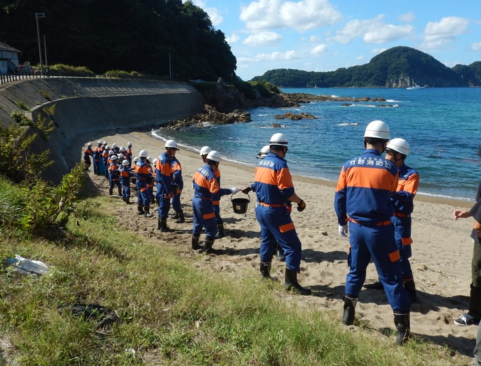 消防団と地域住民によるバケツリレーの写真