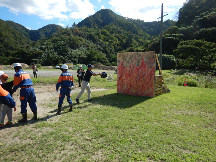 消防団と地域住民によるバケツリレーの写真