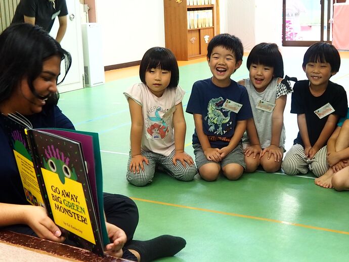 英語遊びの写真：英語の絵本を見る子ども