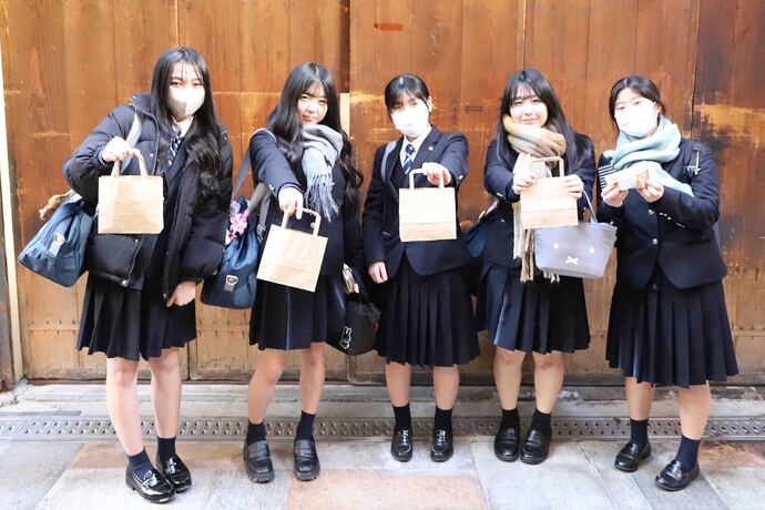 画像：限定割引を受けた商品を持つ高校生