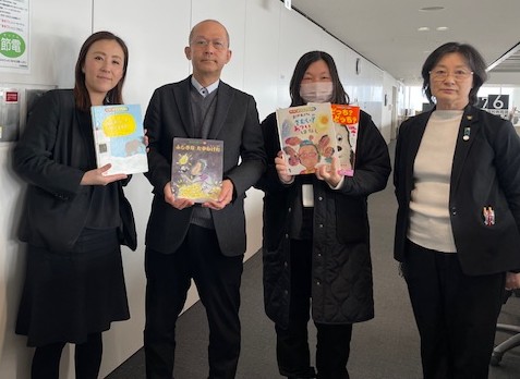 絵本を受け取る正木教育次長（右）