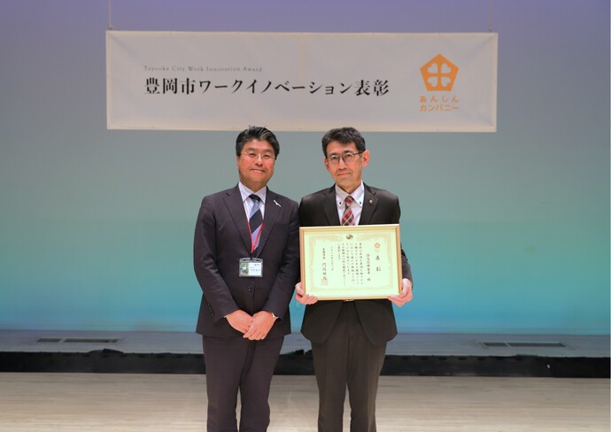 写真：左から、門間雄司市長、あんしんカンパニー2025を受賞した但馬信用金庫 人事部長 石髙真二さん