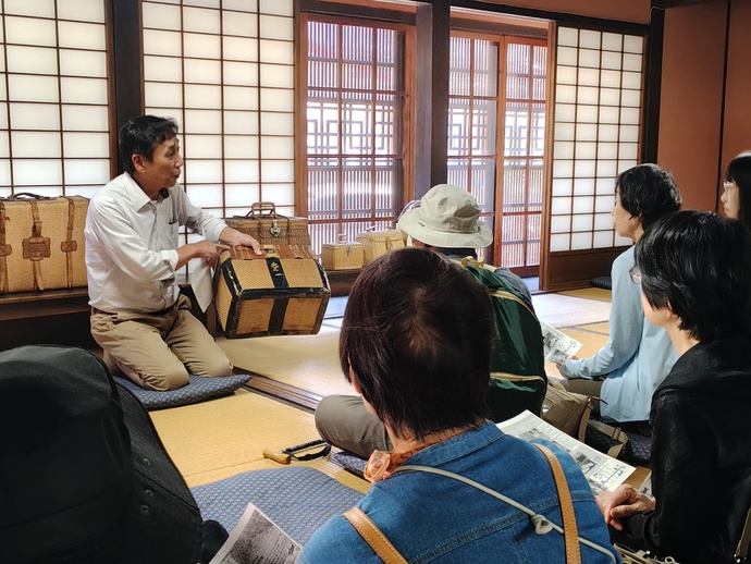 杞柳細工職人の解説に聴き入る参加者ら