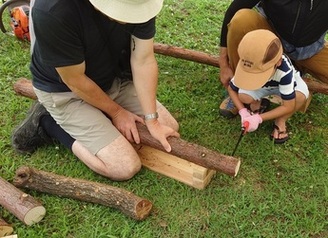 のこぎりで木材を切る子ども